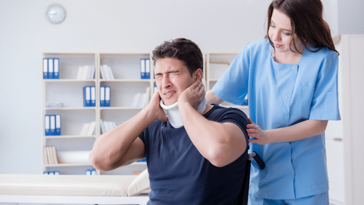 man wearing a neck brace in pain being comforted by a doctor