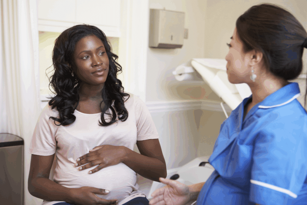 Prenatal chiropractor consulting with pregnant woman