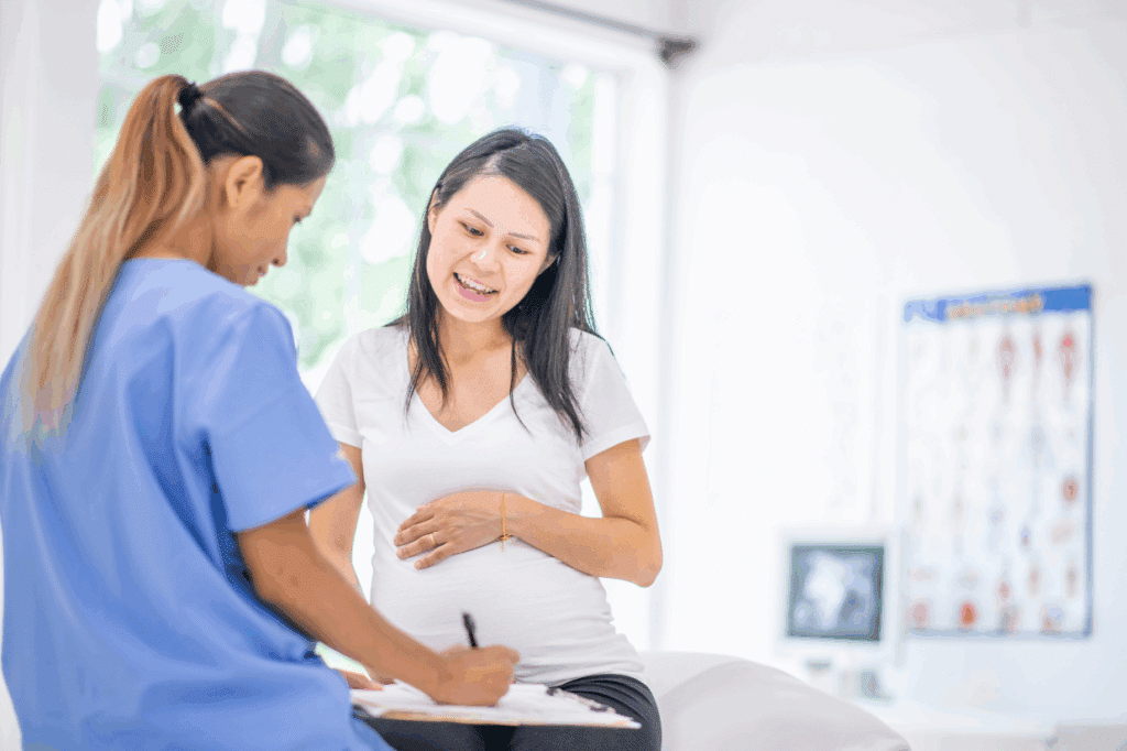 Pregnant woman talking to prenatal chiropractor